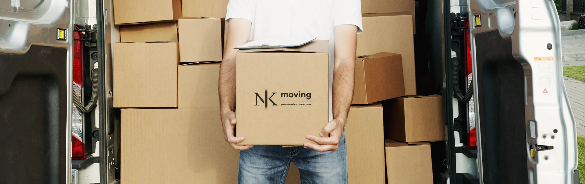 Carrying an NK Moving box beside a van loaded with cartons